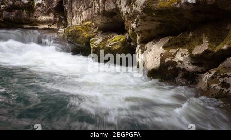 Superbes détails en gros plan et formes de rapides puissants de Mountain creek en cascade sur des rochers rouges et humides d'un canyon Banque D'Images