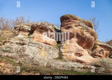 De belles formes de roches rouges érodées couvertes de mousse dorée et ensoleillée sous un ciel bleu dans un canyon de Serbie appelé petit Colorado Banque D'Images