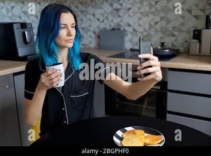 Belle jeune femme taille prenant selfie dans la cuisine moderne Banque D'Images