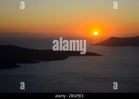 Stantorini : coucher de soleil sur l'île Nea Kameni. Vue de Fira. Grèce Banque D'Images