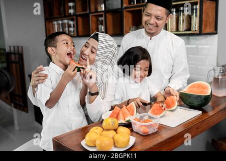 la mère avertira son enfant de cesser de manger le melon d'eau avant le moment de briser le rapide Banque D'Images