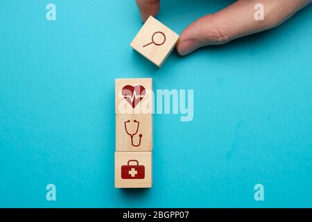 Concept de recherche de soins médicaux avec icônes sur des blocs de bois. Gros plan. Banque D'Images