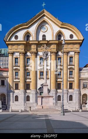 Slovénie, Ljubljana, Église Ursuline de la Sainte Trinité à Kongressni Trg ou place du Congrès avec la colonne Sainte Trinité en face. Banque D'Images