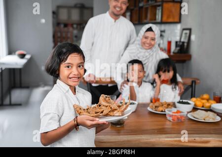 les enfants asiatiques qui ont un menu pour dîner avec une famille Banque D'Images