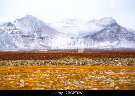 Paysage de montagne enneigé d'Islande devant un champ Banque D'Images