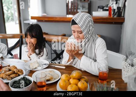 la famille musulmane priait avant de manger sa nourriture. briser le dîner rapide ou iftar Banque D'Images