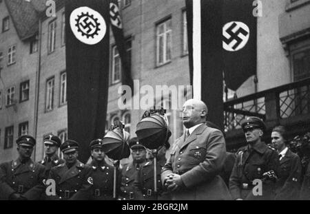 Gauleiter Julius Streicher (1885-1946), prononcera un discours à l'ouverture des concours de troisième artisanat de la province de Franconie sur la place Adolf Hitler, Nurnberg, 2 février 1936, Front des travailleurs allemands, Franconie. Streicher s'occupait des rangs d'hommes et de garçons en uniforme. Notez les grandes déflecteurs ronds qui couvrent et protègent les microphones de la pluie et du vent. Streicher était l'un des premiers partisans d'Hitler et l'a récompensé par une protection contre ceux qui ont détesté les parcours et publications anti-juifs de Streicher. Pour voir mes autres images liées à WW II, recherchez: Prestor millésime WW II Banque D'Images