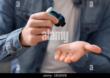 L'homme qui verse du gel désinfectant sur les mains pour la désinfection Banque D'Images