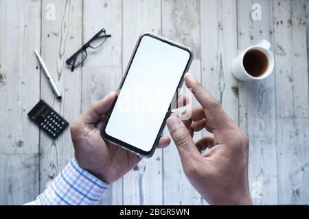 homme tenant son smartphone avec écran vide, vue en grand angle Banque D'Images