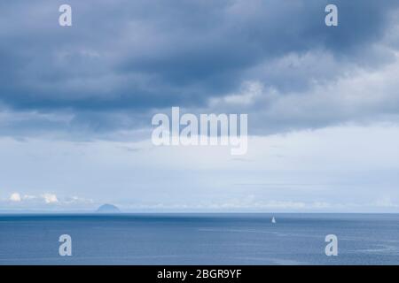 Un seul yacht dans le paysage écossais avec dans l'arrière-plan île Ailsa Craig dans le Firth de Clyde au sud de l'île d'Arran, Ecosse Banque D'Images