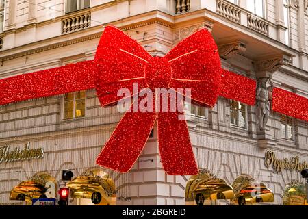 VIENNE, AUTRICHE - NOVEMBRE 2019: Grand noeud fait de lumières de Noël à l'extérieur du magasin de vêtements Popp & Kretschmer dans le centre-ville de Vienne. Banque D'Images