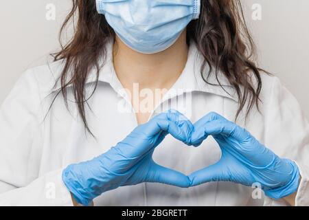 Arrêter SARSCoV, virus 2020 , MERS-CoV, virus chinois COVID-19. Gants médicaux bleus pour femme avec signe cardiaque. Concept de protection contre le VIH Banque D'Images