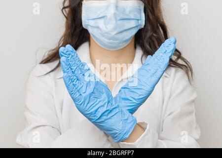 Arrêter le SRAS-COV, le SARSCoV, virus 2020 , virus chinois COVID-19. Les mains des femmes dans des gants médicaux bleus montrent UN SIGNE STOP à la maladie. Médecin portant une protection Banque D'Images