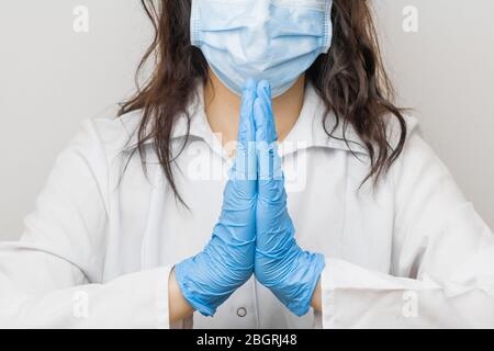 Gants médicaux bleus pour femme, signe Namaste ou Namaskar. Arrêtez SARSCoV, virus 2020, virus chinois COVID-19. Concept de protection contre le VIH Banque D'Images