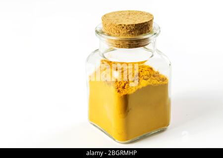 Poudre turmerique en flacon transparent en verre sur fond blanc isolé. Soins de santé, médecine alternative. Banque D'Images