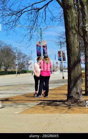 Chicago, Illinois, États-Unis. Deux femmes, dont une porte un masque de visage convergent à Grant Park, mais ne maintenant pas l'exigence de distanciation sociale requise. Banque D'Images