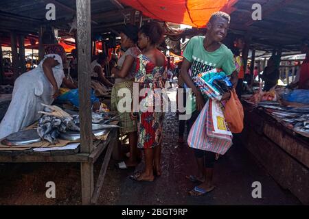 Les clients achètent de la nourriture au marché central de Kisangani en République démocratique du Congo. Les acheteurs et les commerçants savent que le marché bondé augmente leurs chances de tomber avec le coronavirus, mais ne voient pas une autre option. (Françoise Mbuyi, GPJ République démocratique du Congo) Banque D'Images