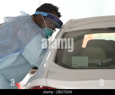 Soldat de la Garde nationale de New York PFC. Daniel Fletcher, prend un échantillon d'écouvillon d'un automobiliste dans un centre de test COVID-19, coronavirus au 20 avril 2020 à Brooklyn, New York. Banque D'Images