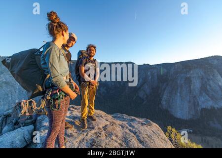 Trois randonneurs au sommet d'El Capitan dans la vallée de Yosemite au coucher du soleil