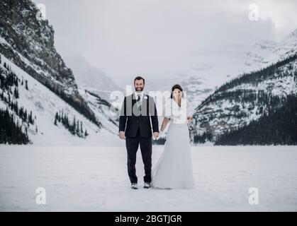 Un couple nouvellement mariés se trouve sur le lac louise, en alberta, au canada, en hiver Banque D'Images