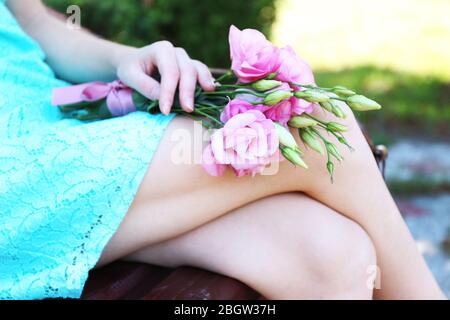 Femme tenant un beau bouquet de fleurs d'eustoma dans le parc Banque D'Images