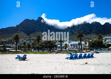 La vie de plage de la baie du camp avec le parc national de Table Mountain chaîne de montagnes en arrière-plan, le Cap, le Cap occidental, Afrique du Sud. Banque D'Images