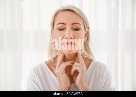 Femme avec problème de glande thyroïde à la maison Banque D'Images