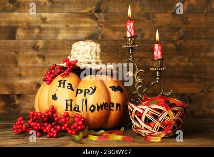Citrouilles et bonbons Halloween dans le panier sur fond de table en bois Banque D'Images