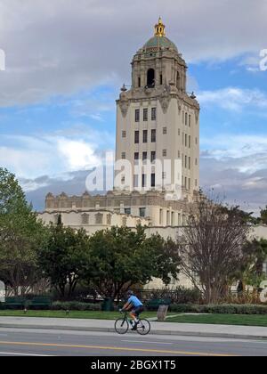 Le vélo solitaire passe devant l'hôtel de ville historique de Beverly Hills, situé sur le boulevard Santa Monica, à Beverly Hills, Californie Banque D'Images