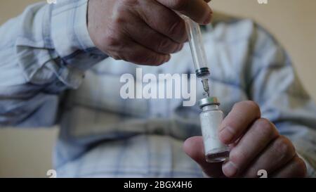 les mains pompent la substance dans le flacon de vaccin Banque D'Images