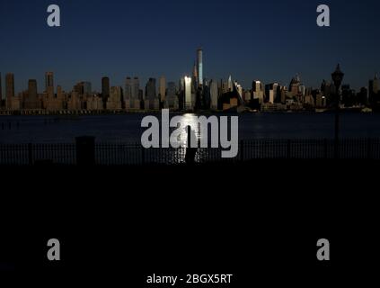 West New York, États-Unis. 22 avril 2020. Un homme marche par la vue sur les gratte-ciel de Manhattan à West New York, NJ le mercredi 22 avril 2020. Chaque année, le 22 avril, la Journée de la Terre marque l'anniversaire de la naissance du mouvement environnemental moderne en 1970. On estime que 2,5 millions de personnes ont été infectées par le nouveau coronavirus à l'échelle mondiale et qu'il a tué plus de 171 000 personnes dans le monde. Environ 25% de ces décès ont été enregistrés aux États-Unis. Photo de John Angelillo/UPI crédit: UPI/Alay Live News Banque D'Images