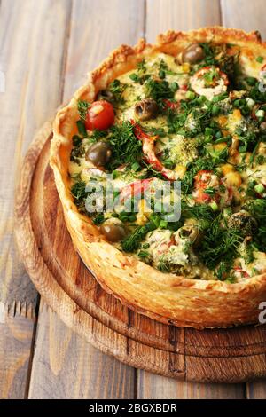 Tarte aux légumes avec brocoli, pois, tomates et fromage sur fond de bois Banque D'Images