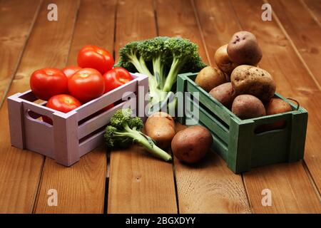 Différents légumes dans des boîtes sur fond en bois vue de dessus Banque D'Images