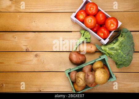 Différents légumes dans des boîtes sur fond en bois vue de dessus Banque D'Images