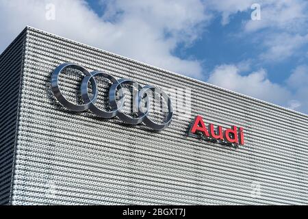 Logo et texte Audi quatre anneaux à l'extérieur d'une concession Audi. Banque D'Images