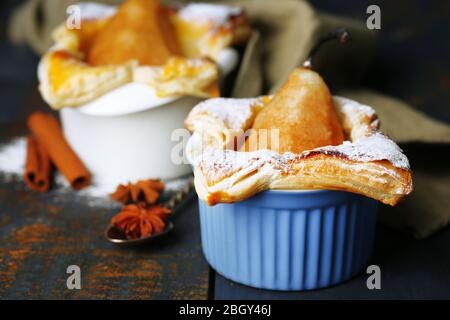 Petites tartes de poire en tasses, sur table en bois Banque D'Images