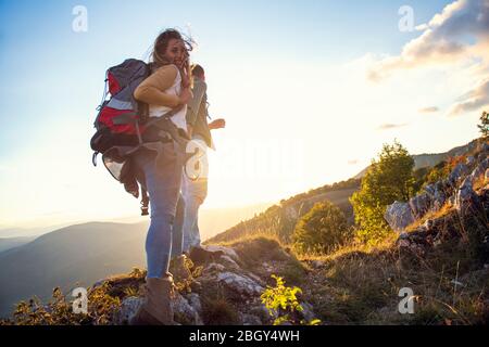 Les randonneurs avec des sacs à dos se détendre au sommet d'une montagne et profiter de la vue de la vallée Banque D'Images