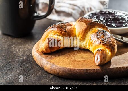 Croissants maison sucrés avec du pavot sur la table de cuisine. Banque D'Images