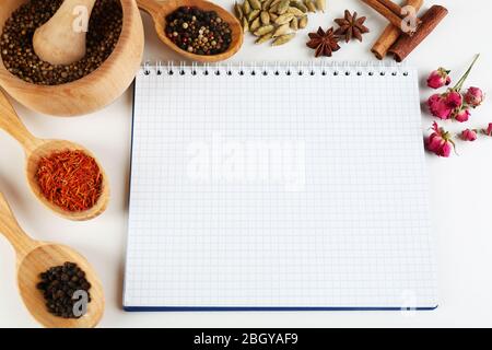 Épices avec livre de recettes sur fond blanc Banque D'Images