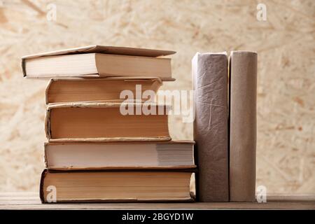 Pile de livres sur fond de bois de planche rigide Banque D'Images