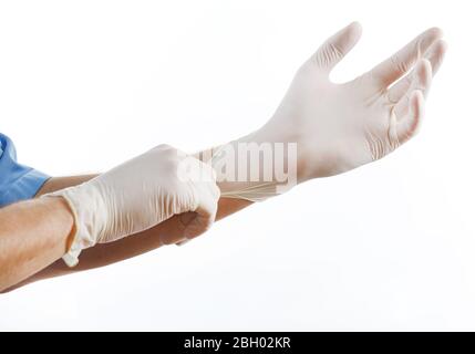 Médecin mettant des gants stériles isolés sur blanc Banque D'Images