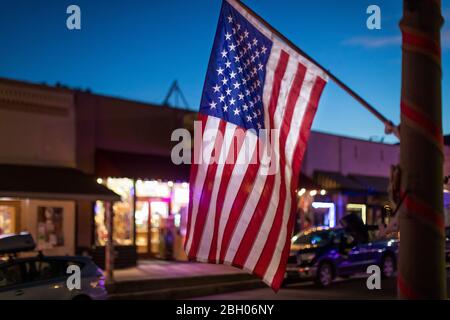 Au crépuscule, un drapeau américain est accroché à l'extérieur d'un magasin dans un petit village du sud-ouest Banque D'Images