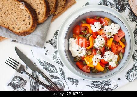 Salade saine avec poivre grillé, tomates, straciatella, herbes et graines de citrouille. Concept de saine alimentation. Banque D'Images