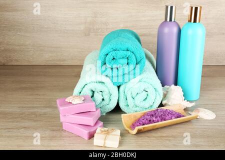 Spa composition with towels and sea salt on wooden background Banque D'Images