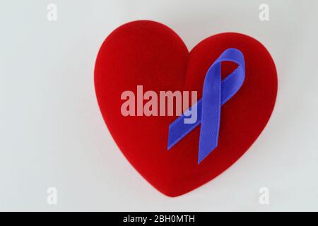 Coeur avec ruban bleu sur fond blanc - concept de sensibilisation au cancer de la prostate Banque D'Images