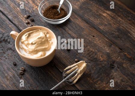 Café Dalgona. Recette coréenne tendance de café fouetté, de latte inversée ou de café dalgona maison sur bois, espace copie. Banque D'Images