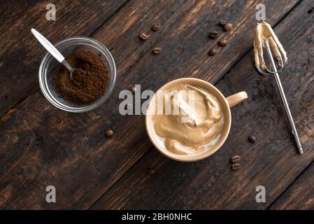 Café Dalgona. Recette coréenne tendance de café fouetté, de latte inversée ou de café dalgona maison sur bois, vue sur le dessus. Banque D'Images