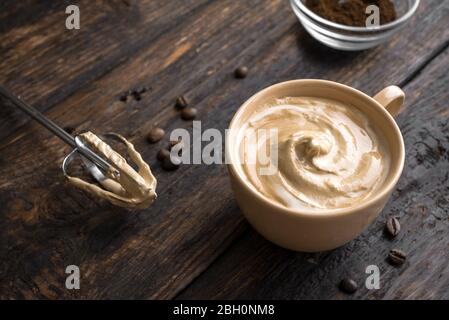 Café Dalgona. Recette coréenne tendance de café fouetté, de latte inversée ou de café dalgona maison sur bois, espace copie. Banque D'Images