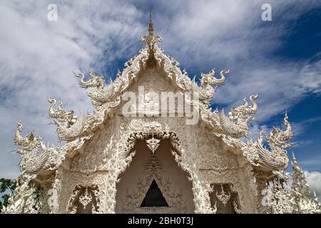 Temple blanc connu sous le nom de Wat Rong Khun avec son reflet dans l'eau, à Chiang Rai, Thaïlande. Banque D'Images
