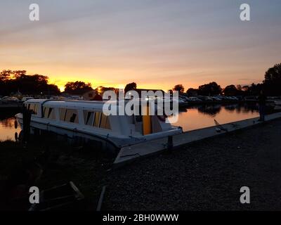 Bateau de vacances amarré à Stalham sur les Norfolk broads sous un coucher de soleil doré Banque D'Images